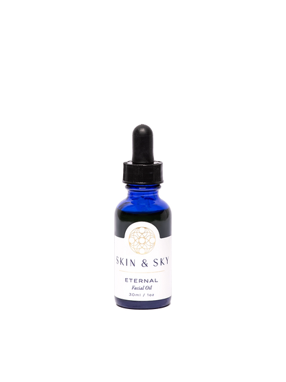 Frasco premium azul de Eternal Facial Oil de Skin & Sky, con gotero negro y etiqueta minimalista en tonos oro y blanco que dice 'Eternal Facial Oil'. Aceite antioxidante de 30 ml / 1 oz que ilumina, hidrata y rejuvenece la piel con ingredientes naturales como semilla de granada y hemp.