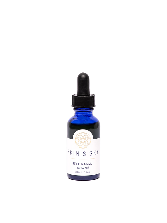 Frasco premium azul de Eternal Facial Oil de Skin & Sky, con gotero negro y etiqueta minimalista en tonos oro y blanco que dice 'Eternal Facial Oil'. Aceite antioxidante de 30 ml / 1 oz que ilumina, hidrata y rejuvenece la piel con ingredientes naturales como semilla de granada y hemp.