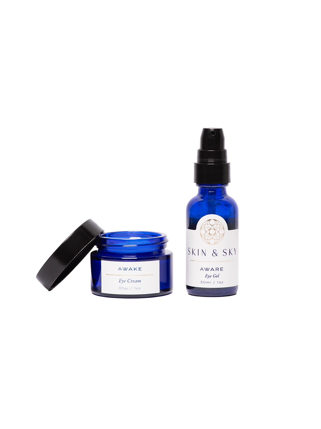 Modelo aplicando el Gaze Set de Skin & Sky: sostiene el AWARE Eye Gel y la AWAKE Eye Cream frente a un fondo azul. Se muestran puntos de producto bajo los ojos para ilustrar la rutina de hidratación y rejuvenecimiento de la mirada.
