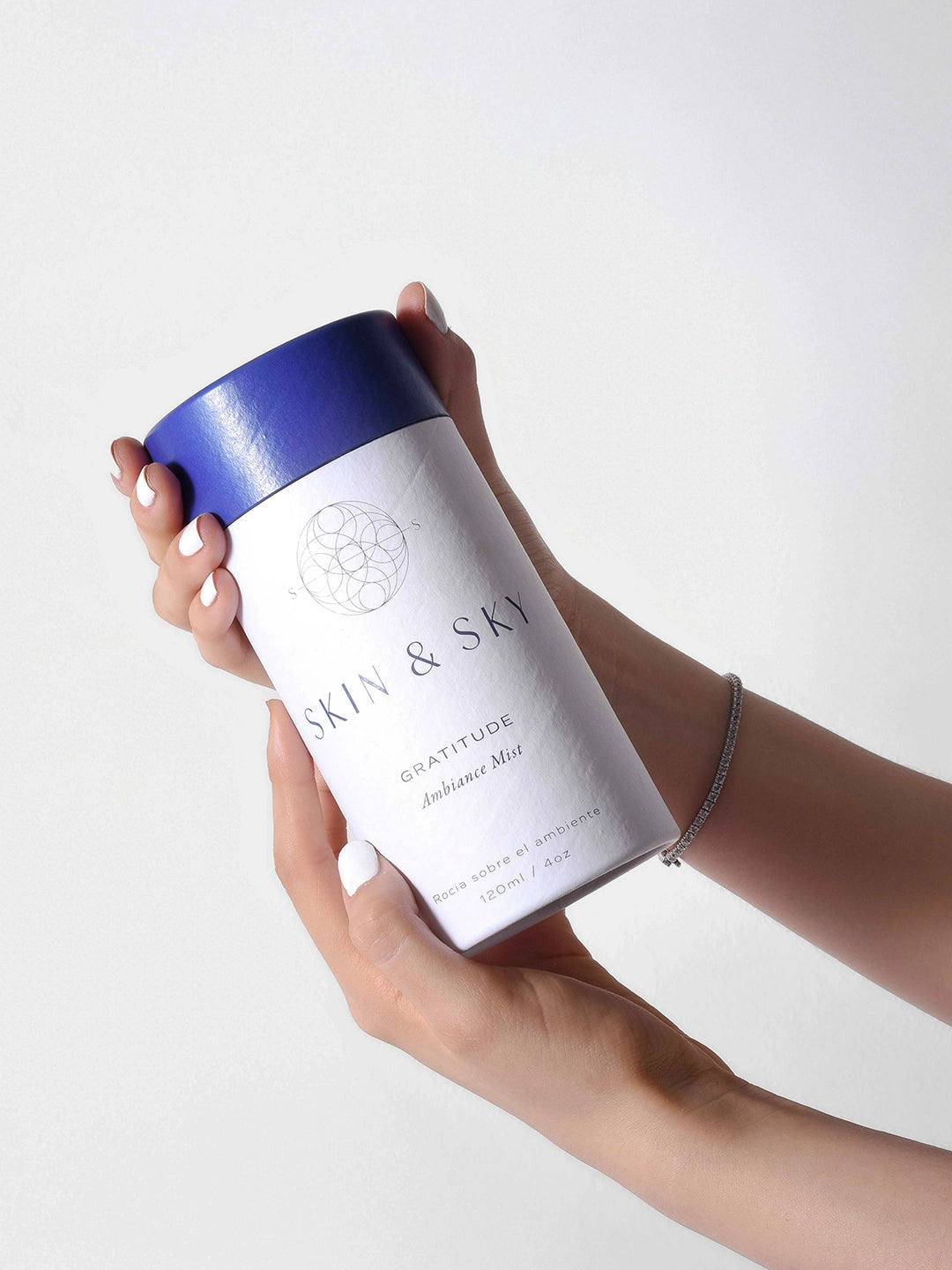 Tres envases de Gratitude Ambiance Mist Skin & Sky sobre superficie reflejante, bruma aromática con aceites esenciales para armonizar espacios, 120 ml.