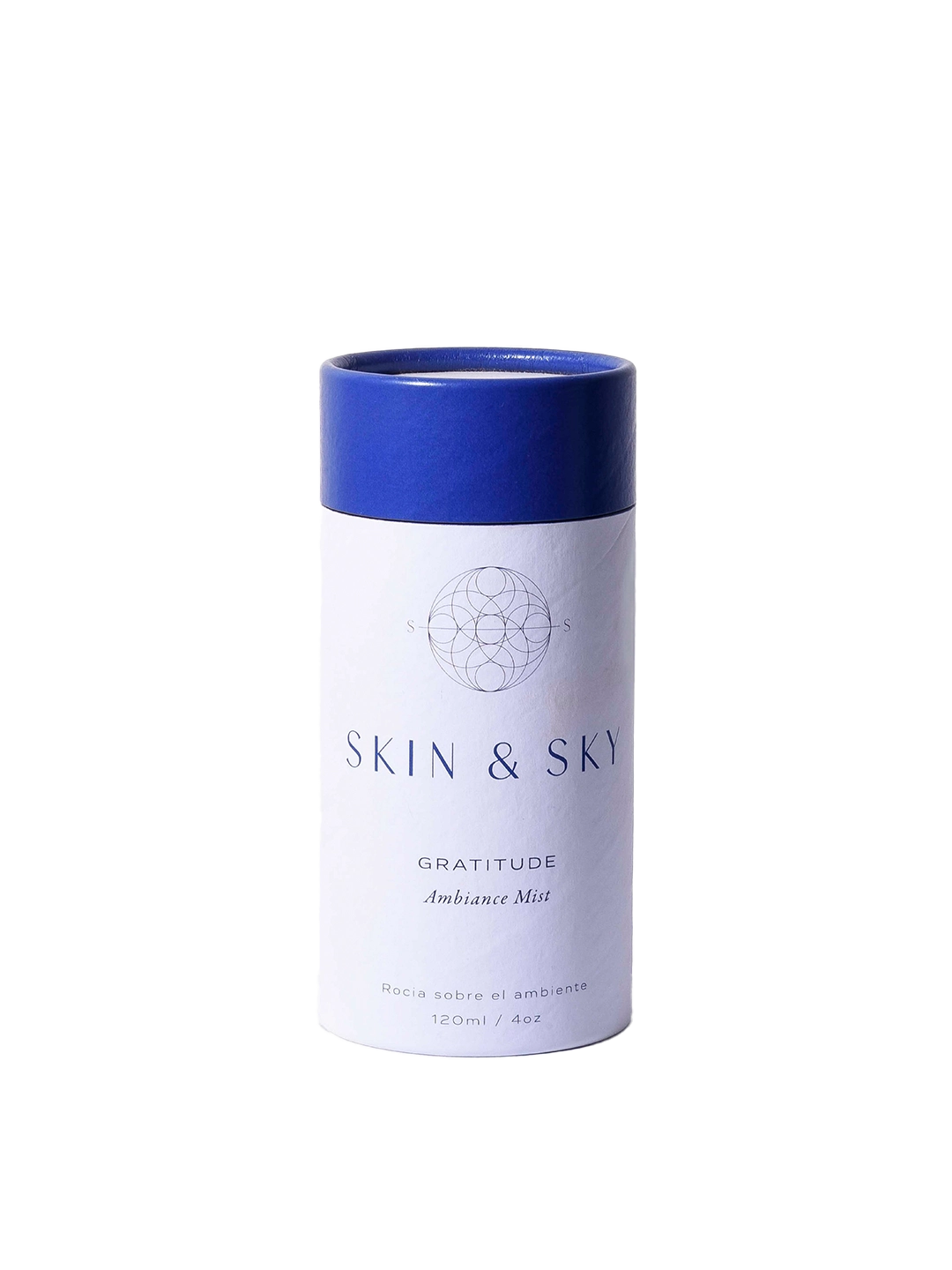 Gratitude Ambiance Mist Skin & Sky en envase cilíndrico blanco con tapa azul sostenido en manos, bruma aromática para armonizar el ambiente, 120 ml.
