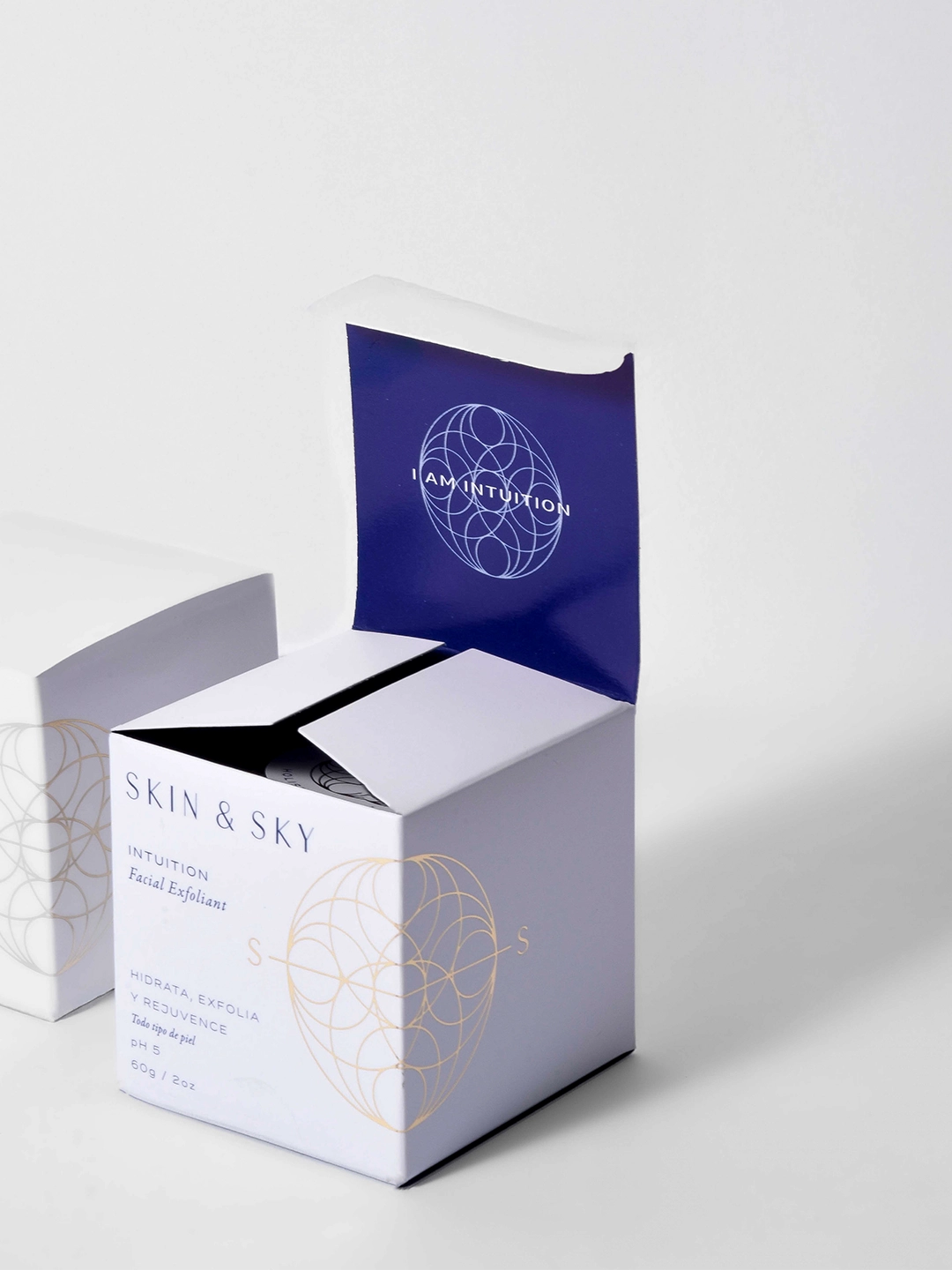 Exfoliante facial Intuition de Skin & Sky en tarro de vidrio azul de 60g con su caja; tratamiento rejuvenecedor con arcilla de caolín y súper alimentos para todo tipo de piel.