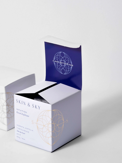Exfoliante facial Intuition de Skin & Sky en tarro de vidrio azul de 60g con su caja; tratamiento rejuvenecedor con arcilla de caolín y súper alimentos para todo tipo de piel.
