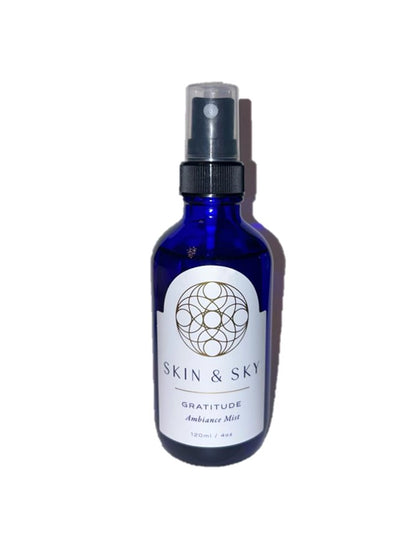 Gratitude Ambiance Mist Skin & Sky en frasco azul con atomizador, bruma energética con aceites esenciales para armonizar el entorno, 120 ml.