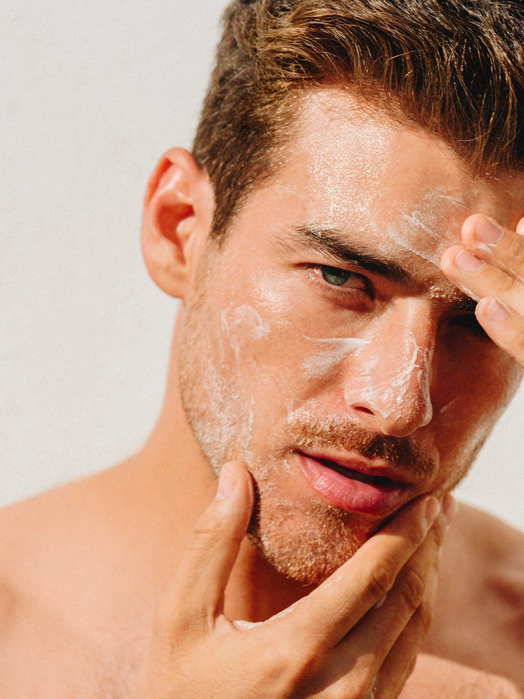 Hombre aplicando espuma cremosa y refrescante de In Love Facial Wash en el rostro y mentón, mostrando textura ligera y hidratante.