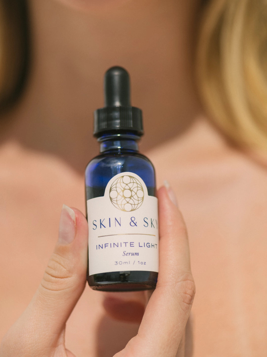 Aplicación del suero Infinite Light para resaltar el brillo natural de la piel; se observa un rostro iluminado y con textura mejorada gracias a su efecto de renovación celular.