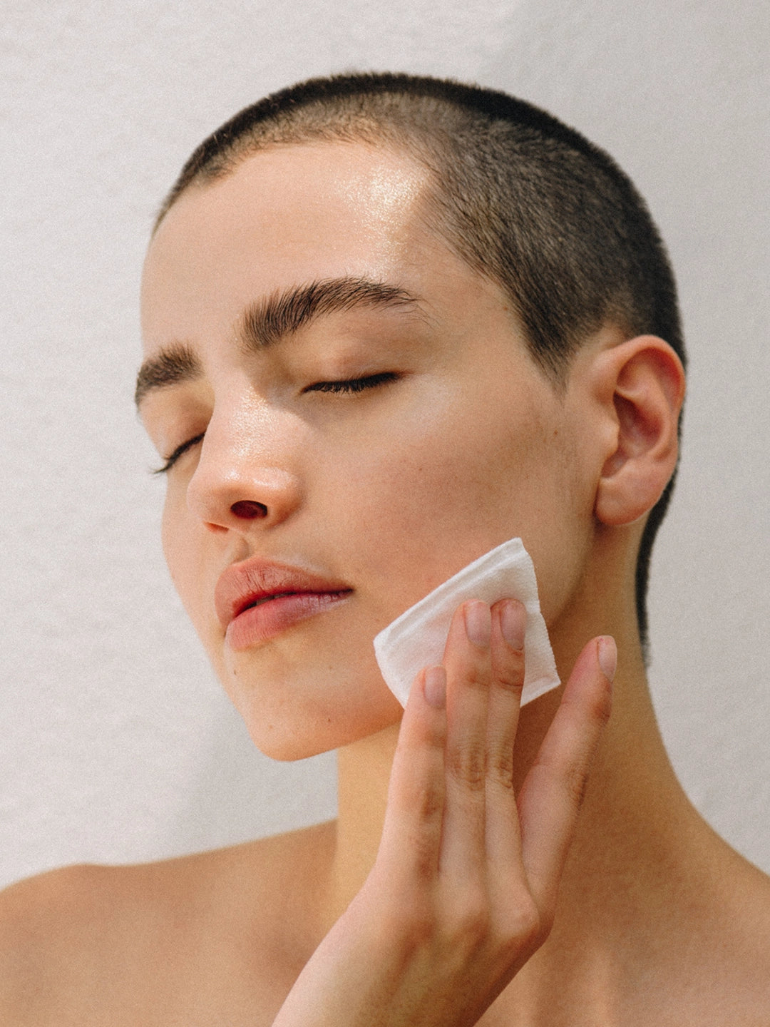 Persona utilizando un pad de algodón para limpiar el rostro con el agua micelar Peace of Mind, mostrando una piel fresca, hidratada y libre de impurezas.