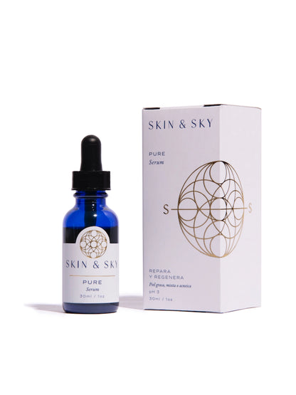 Frasco de vidrio azul de Pure Serum de Skin & Sky junto a su empaque blanco, un suero facial reparador para piel grasa, mixta o acneica con pH 3.