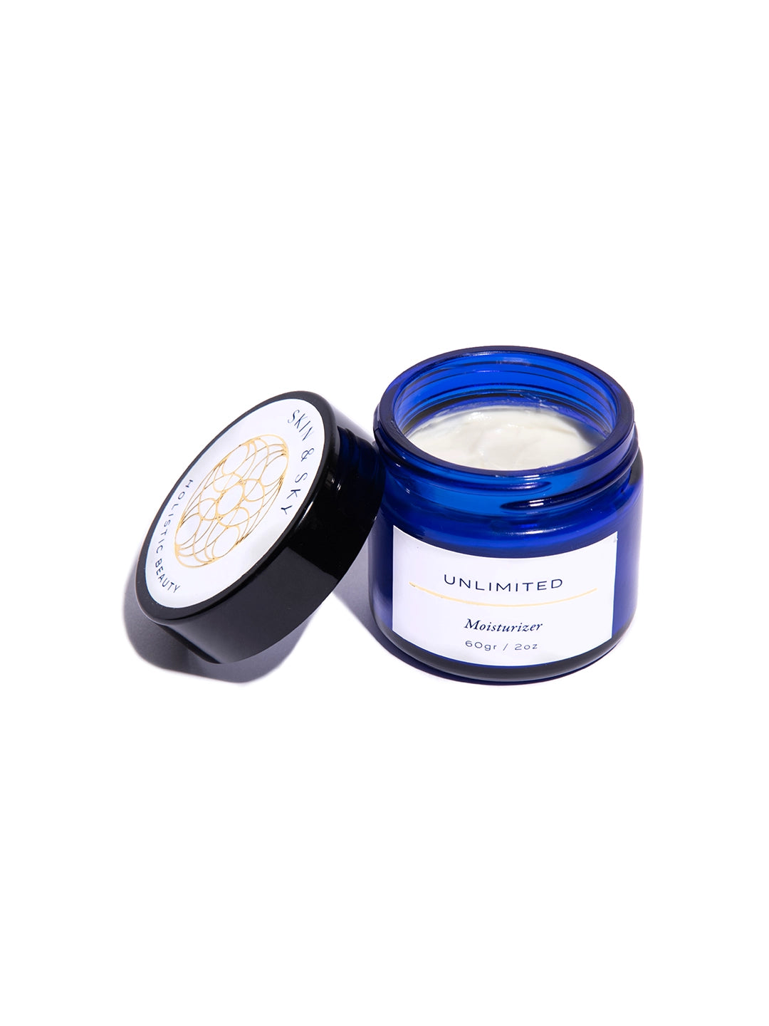 Vista superior del interior del envase azul cobalto mostrando la textura rica y cremosa de Unlimited Moisturizer, formulada con ácido hialurónico y vitamina C.